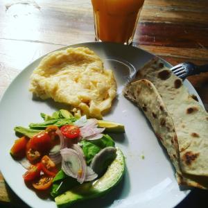 einen Teller mit einem Salat und einem Omelett in der Unterkunft Sina Village in Mpigi