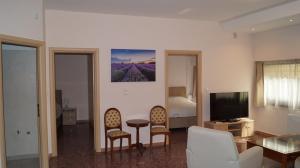a living room with a table and chairs and a television at Luxury Apartment in Plaka - Acropolis (Lavender) in Athens