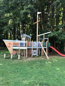 a playground in a park with a slide at Ferienhaus ˋLichtblickˋ in Rheinsberg