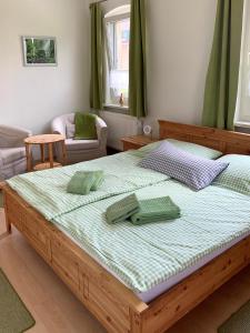 - un grand lit avec 2 oreillers verts dans l'établissement Gasthaus & Pension Zirkelstein, à Schöna