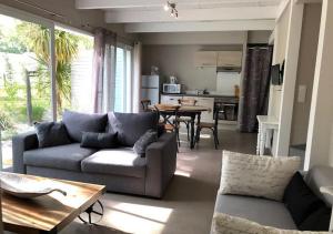uma sala de estar com um sofá e uma mesa em Les cottages du golf em Le Tronchet