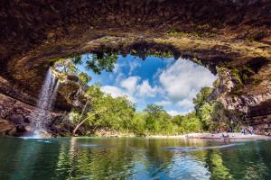 a cave with a waterfall and a body of water at Hill Country Haute n Haus Relax and Renew in Fischer
