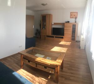 a living room with a coffee table on a wooden floor at Ferienwohnung "Zwei Birken" in Ellwangen