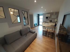 a living room with a couch and a kitchen with a table at Studio Le Ménascle in Saint-Georges-de-Luzençon