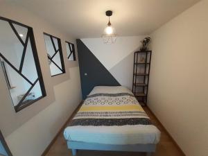 ein kleines Schlafzimmer mit einem Bett und einem Fenster in der Unterkunft Studio Le Ménascle in Saint-Georges-de-Luzençon