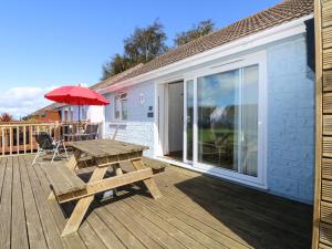 a wooden deck with a picnic table and an umbrella at Drake Cottage in Seaview