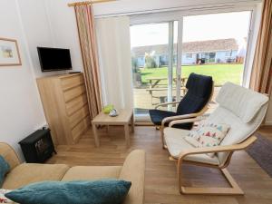 ein Wohnzimmer mit einer Couch und zwei Sesseln in der Unterkunft Drake Cottage in Seaview