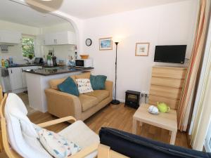 uma sala de estar com um sofá e uma cozinha em Drake Cottage em Seaview