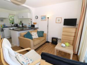 ein Wohnzimmer mit Couch und Küche in der Unterkunft Drake Cottage in Seaview
