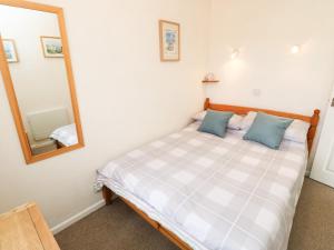 a bedroom with a bed and a mirror at Drake Cottage in Seaview