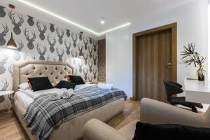 a bedroom with a bed and a desk and a chair at Rezydencja Sobiczkowa Apartamenty in Zakopane +58 photos