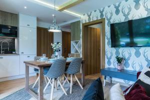 a dining room with a table and chairs at Rezydencja Sobiczkowa Apartamenty in Zakopane