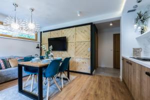 a dining room and living room with a table and chairs at Rezydencja Sobiczkowa Apartamenty in Zakopane