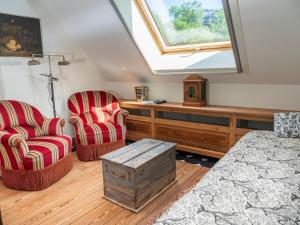 um quarto com 2 cadeiras, uma cama e uma janela em De dag des Heeren em Merendree
