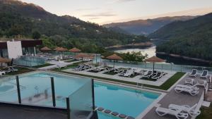 a hotel with a swimming pool with a view of a river at DOBAU village in Vieira do Minho