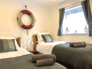 a bedroom with two beds and a mirror and a window at Seaview, Luxury apartment, 2 min walk to both Porth and Whipisderry beaches in Newquay