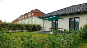a house with a patio with a table and an umbrella at Ferienwohnung mit Terrasse in Neustrelitz