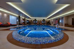 uma grande piscina de água no átrio do hotel em Grand Millennium Tabuk em Tabuk