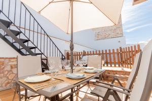 ein Esszimmer mit einem Tisch, Stühlen und einer Treppe in der Unterkunft Cubo's Casa El Torcal in Villanueva de la Concepción