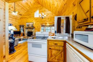 una cocina con electrodomésticos blancos en una cabaña de madera en Sugar Maple en Blue Ridge