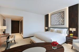 a hotel room with a large bed and a large window at Sofitel Dubai The Obelisk in Dubai