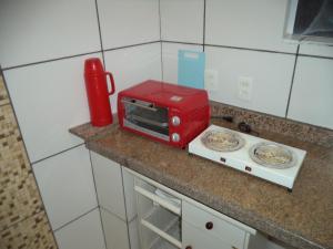 a red toaster sitting on a counter in a kitchen at Jóias Preciosas- Kitnet Mobiliado in Campinas