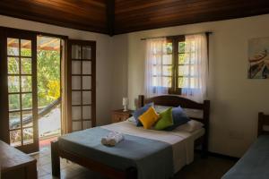 een slaapkamer met een bed en een groot raam bij L´Grace Ferradura in Búzios +84 foto's
