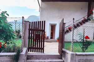 a gate to a house with a fence and flowers at Apartma Sašo in Srpenica +4 photos