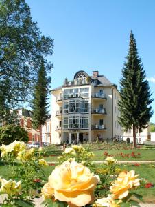 a large building with flowers in front of it at 28 qm Apartments am Rosengarten in Bad Elster
