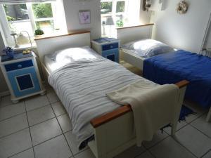 two beds in a room with two blue night stands at Appartement Dorfstrasse in Glücksburg