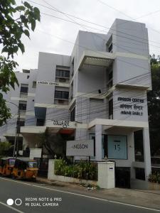 a large white building on the side of a street at Angson Apartment in Chennai