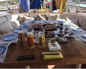una mesa de madera con comida y bebidas en un barco en Southern Cross en Barcelona