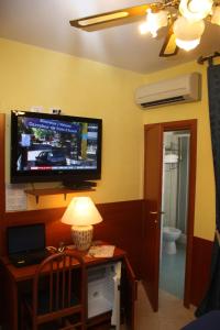a room with a desk with a television on a wall at Viennese Due in Rome