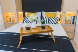 Una cama con una mesa de madera con flores. en Sevastopol apartments Varna en Varna