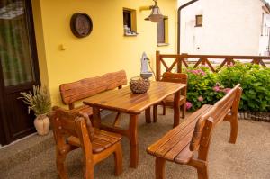 a wooden table and benches in a patio at Penzion Holacký in Dolní Dunajovice
