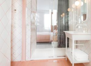 a bathroom with a shower with a sink and a mirror at Hotel le Lapin Blanc in Paris
