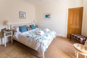 a bedroom with a large bed with blue pillows at Whitehaven in North Berwick