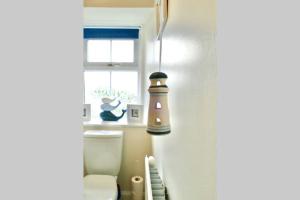 a bathroom with a toilet and a window at St Brendans Apartment in Elgin