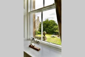 a window with a boy looking out of it at St Brendans Apartment in Elgin