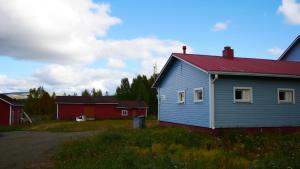 a blue house with a red roof next to a red barn at TaloYlläs, Huonemajoitus in Äkäslompolo