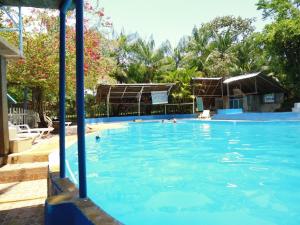 a large swimming pool with people in the water at Villa Hermosa de Tambopata Casa Hospedaje & Hostel in Puerto Maldonado