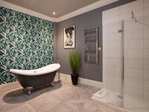 a bathroom with a bath tub and a plant at Alma Apartments In A Perfect Location in Bristol