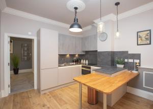 Alma Apartments In A Perfect Location في بريستول: مطبخ مع طاولة خشبية في الغرفة