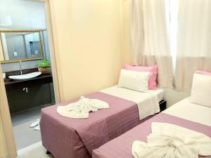 a small room with two beds and a mirror at Villa Araçà - Boutique Hotel in Lauro de Freitas