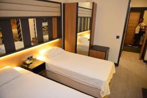 En eller flere senge i et værelse på Oasis Hotel