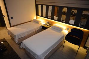 En eller flere senge i et værelse på Oasis Hotel