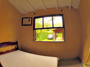 Recanto dos Katzen في ماريسياز: غرفة نوم بسرير ونافذة