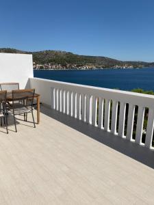 a balcony with a table and chairs and the water at Apartman S&D Rogoznica in Rogoznica