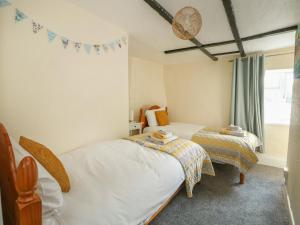 a bedroom with two beds and a window at Cobbler's Cottage in Norwich