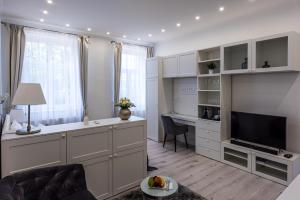 uma sala de estar com um sofá e uma secretária com uma televisão em Noemiz Exclusive Apartments em Budapeste